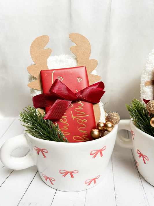 Weihnachtsgeschenk für Freundin mit dekorativer Tasse, kuscheligen Socken und weihnachtlicher Schokolade.